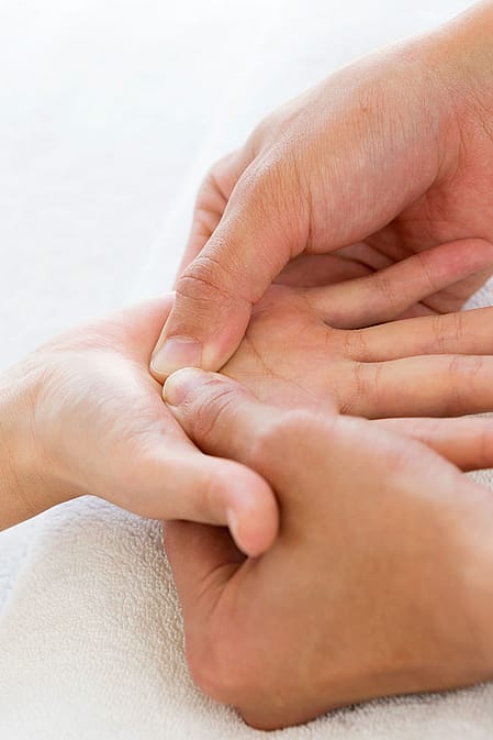 Frau führt Handmassage durch