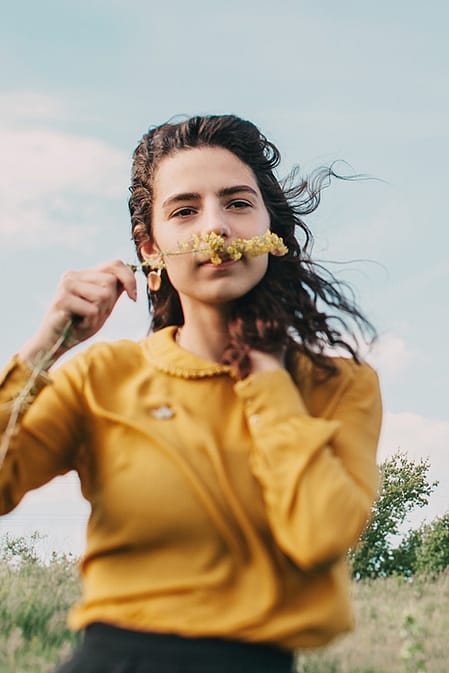 Junge Frau riecht an Blume