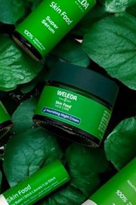 Weleda Skin Food range on a bed of green leaves