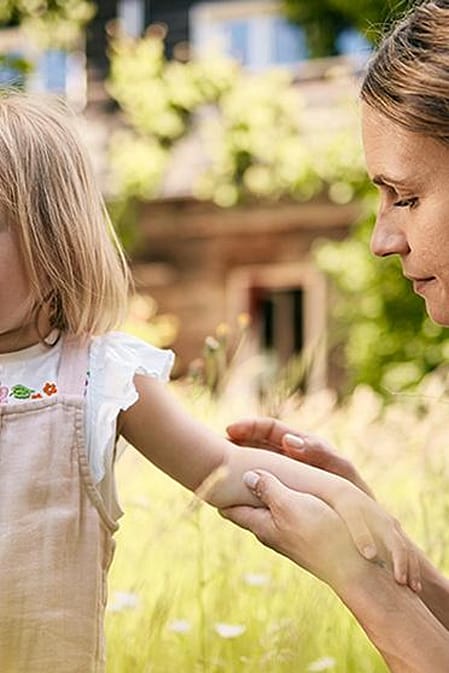 une femme traite une piqûre d'insecte de son enfant