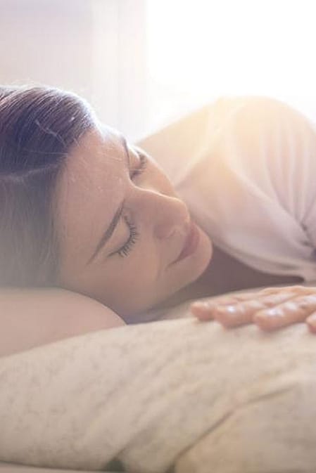 Frau schlaeft entspannt auf der Seite