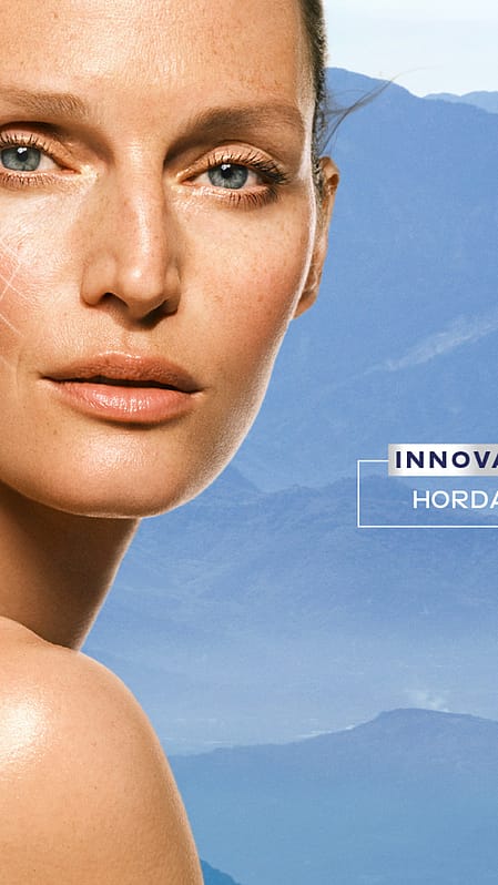 Retrato de una mujer frente a unas montañas azules.