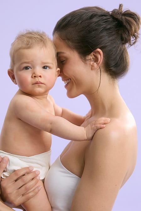 madre cambiando pañal a bebe sonriendo