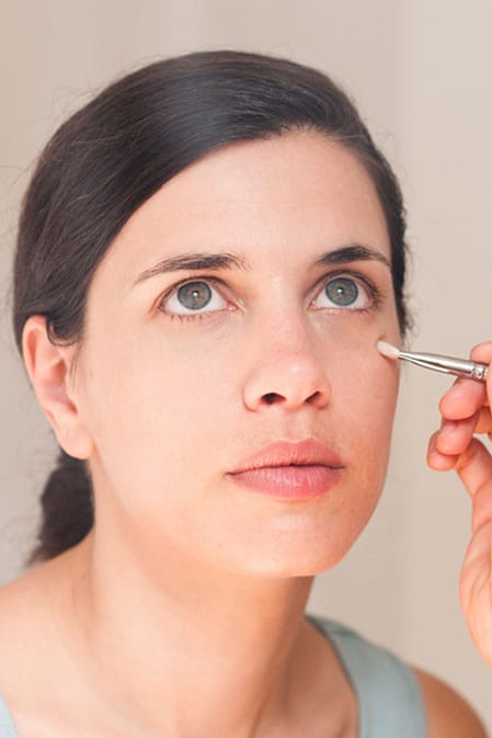 mujer maquillando a otra mujer