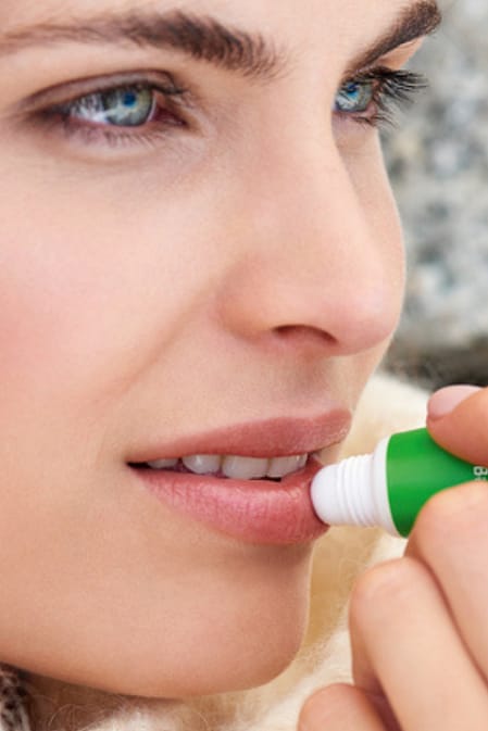 mujer usando lip balm de weleda