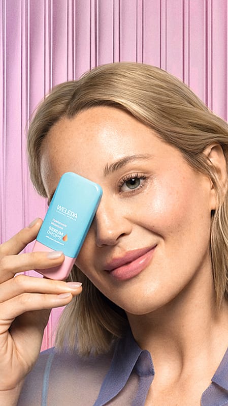 jeune femme blonde tenant le booster drop Hyaluronic Serum devant son visage