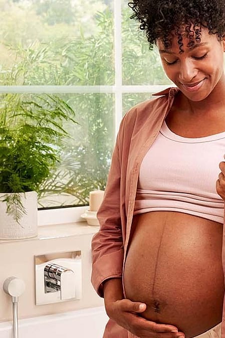 mujer embarazada sonriendo tocandose la tripa