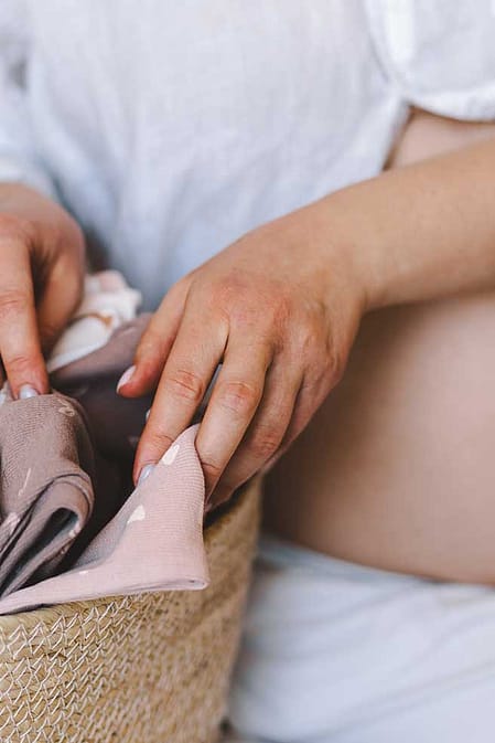 Schwangere mit Babykleidung