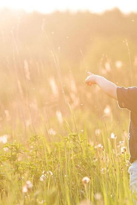 niño de la maño de su padre paseando por el campo