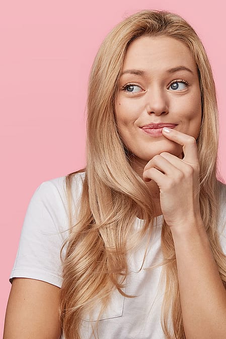 Junge Frau legt ihren Finger an die Lippen