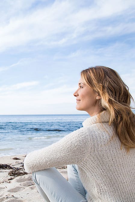 Frau sieht aufs Meer hinaus