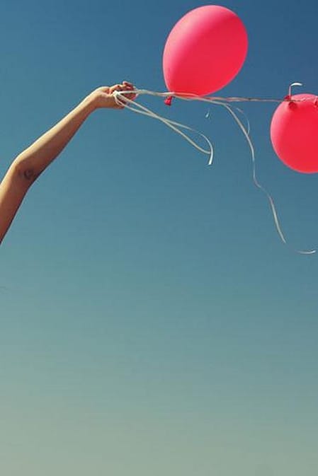 mujer embarazada agarrando unos globos