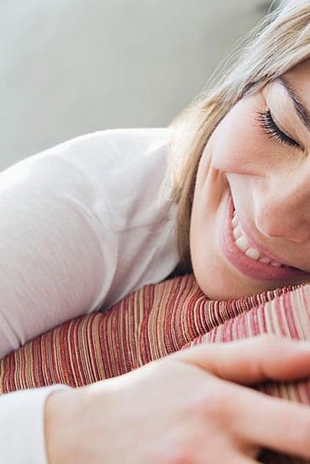 mujer tumbada en un sofa sonriendo