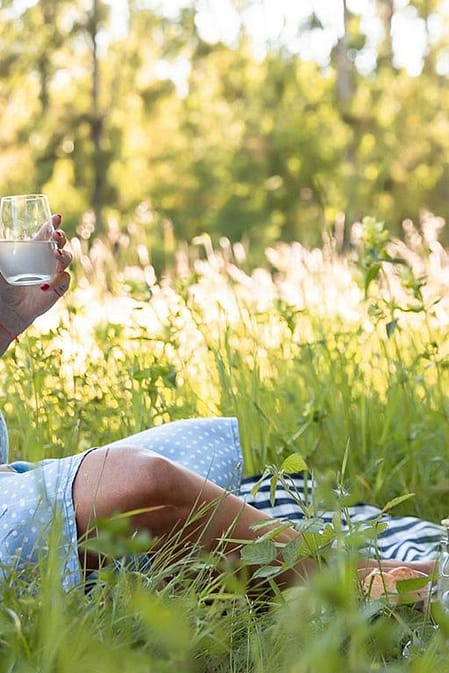 Schwangere Frau im Grass mit Kissen und zu trinken