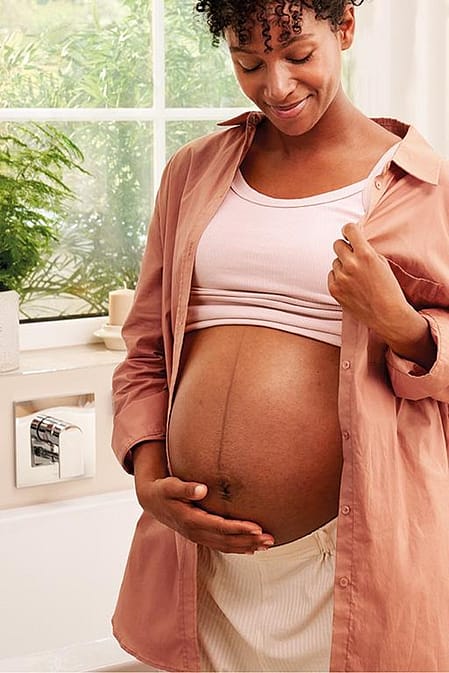 mujer embarazada echandose crema hidratante