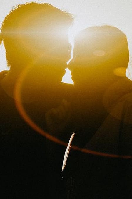 Eine Frau und ein Mann kuessen sich im Gegenlicht