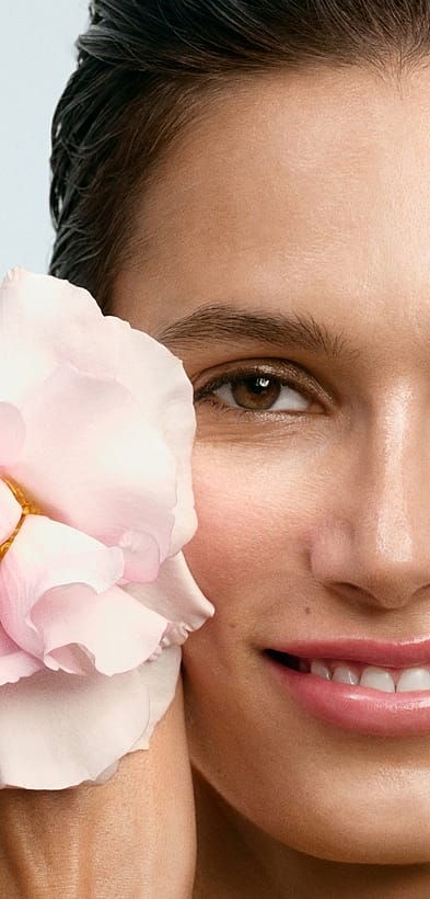 Kvinna meed blomma vid ansiktet