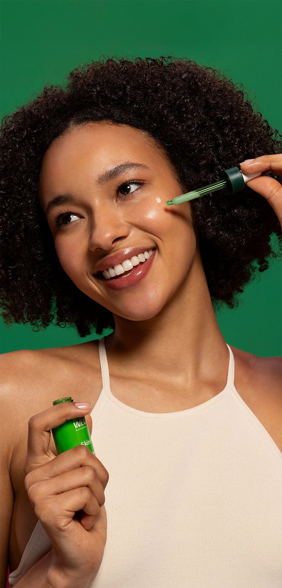 Närbild på tjej som droppar Skin Food Super serum på kinden