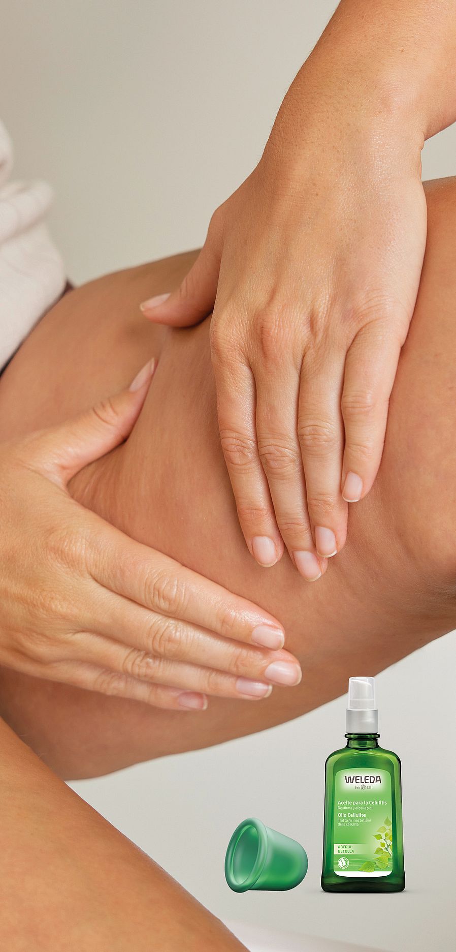 Banner promo linea betulla: mani massaggiano una gamba con olio anticellulite alla betulla con la coppetta per i massaggi in omaggio