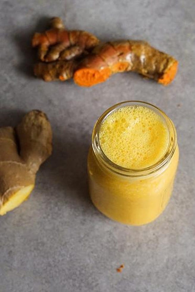 Ingwer Shot im Glas und frischen Ingwer