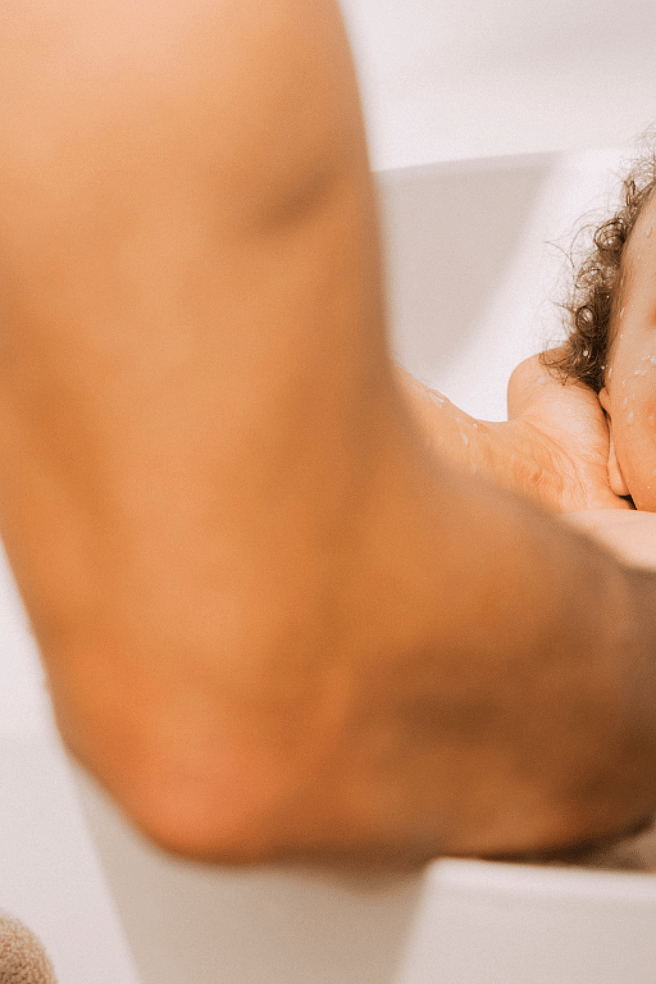Mujer bañando a un bebé en una bañera