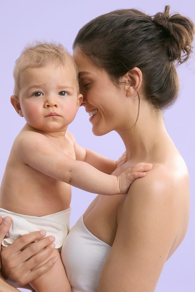 madre cambiando pañal a bebe sonriendo