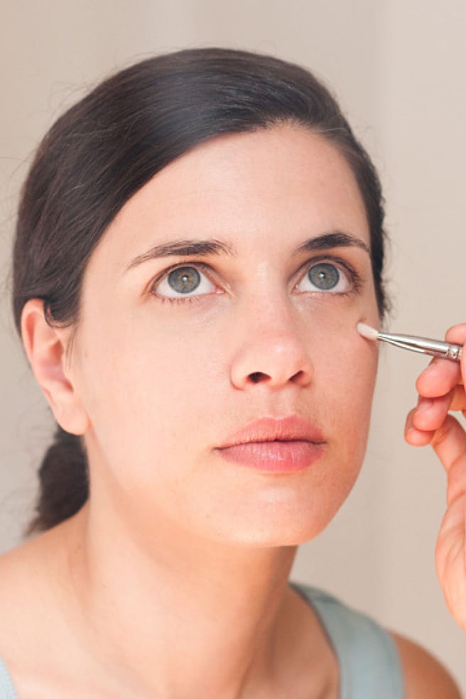 mujer maquillando a otra mujer