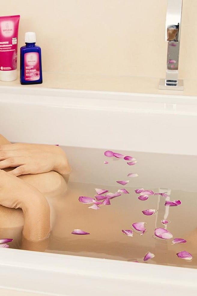 femme dans son bain avec des pétales de fleurs