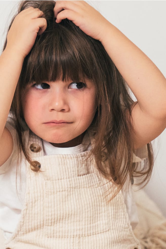 petite fille qui se gratte la tête