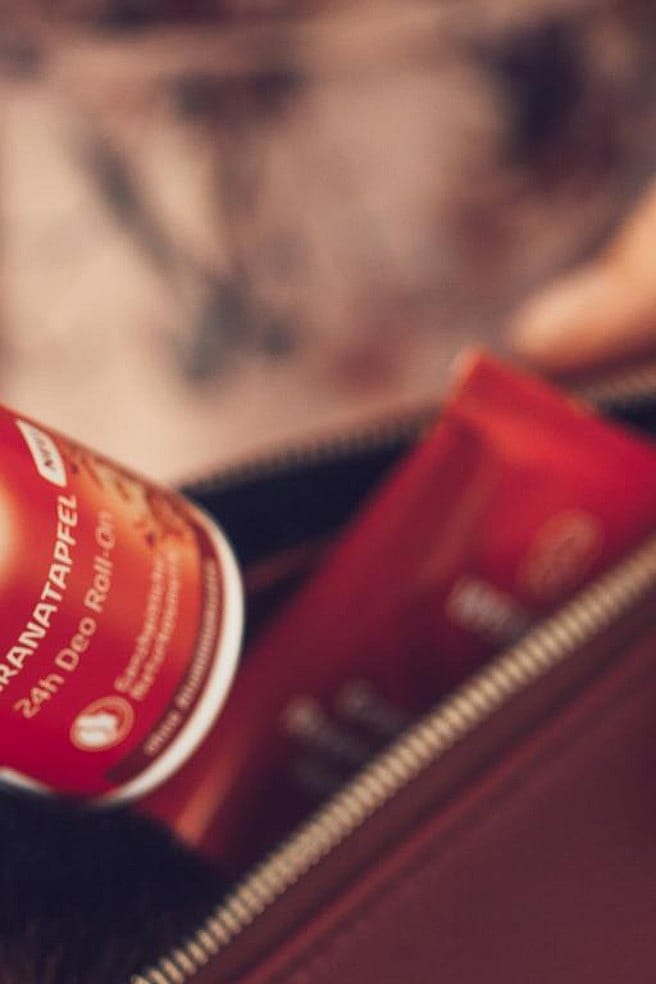 mano guardando el desodorante roll-on de granada de weleda en un bolso