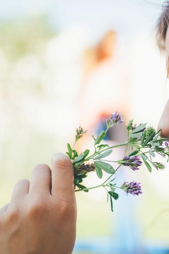 mujer oliendo flores