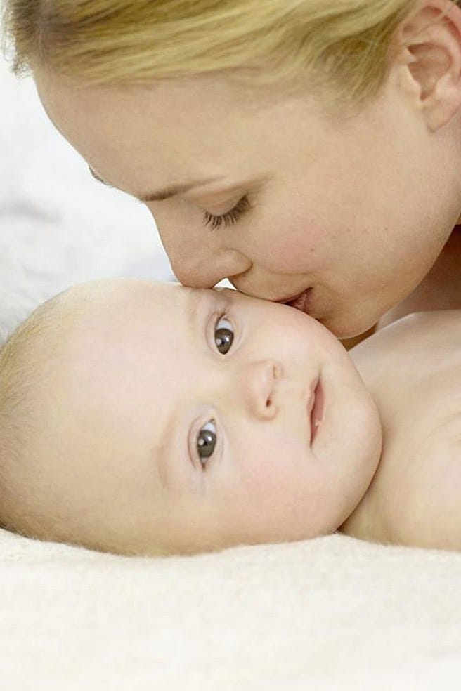 mother kissing baby