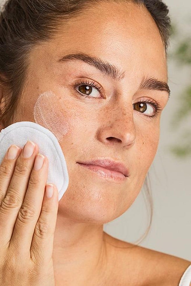 une femme se nettoie le visage