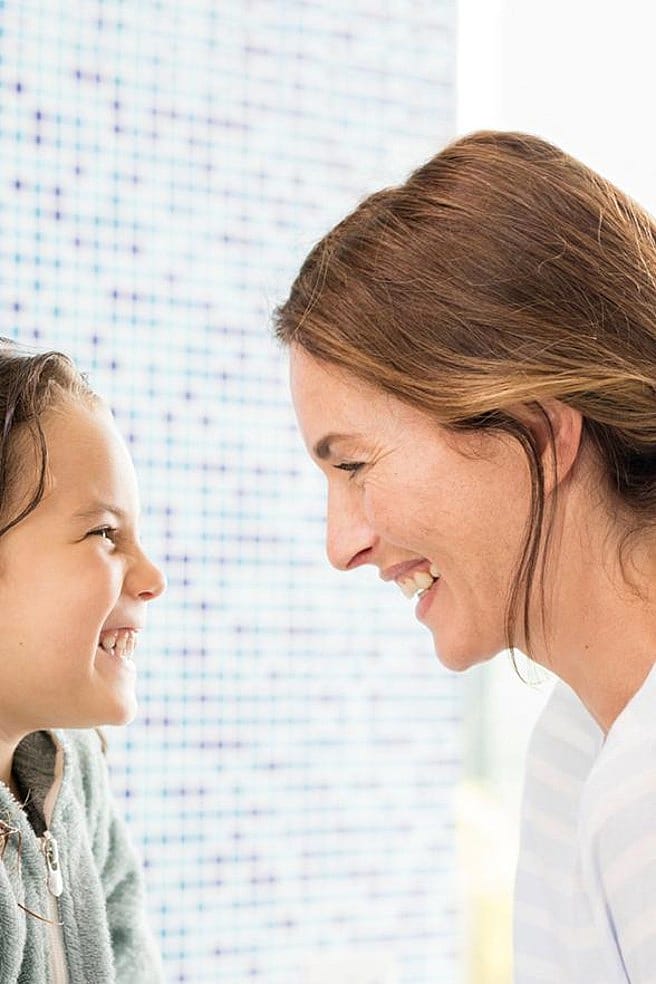 madre e hija mirándose mientras sonríen