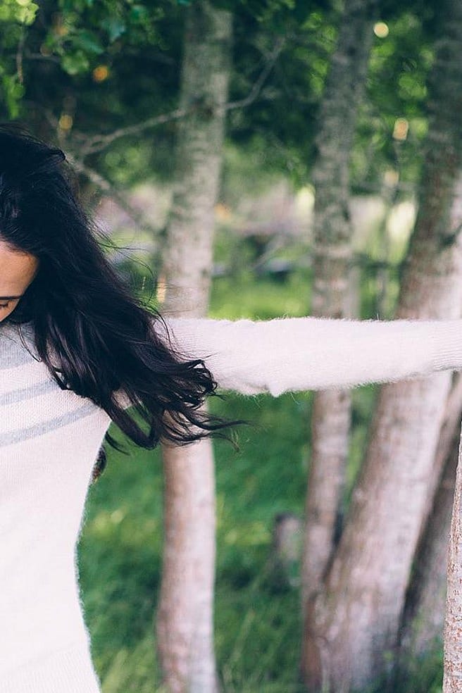 mujer apoyada en un abedul