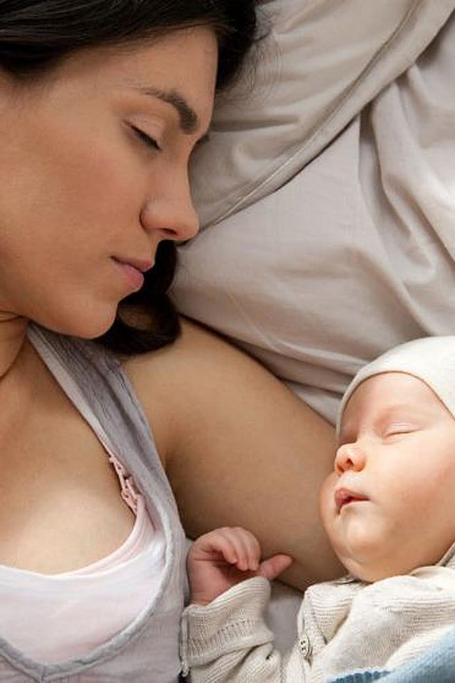 mujer y bebé tumbados en una cama durmiendo