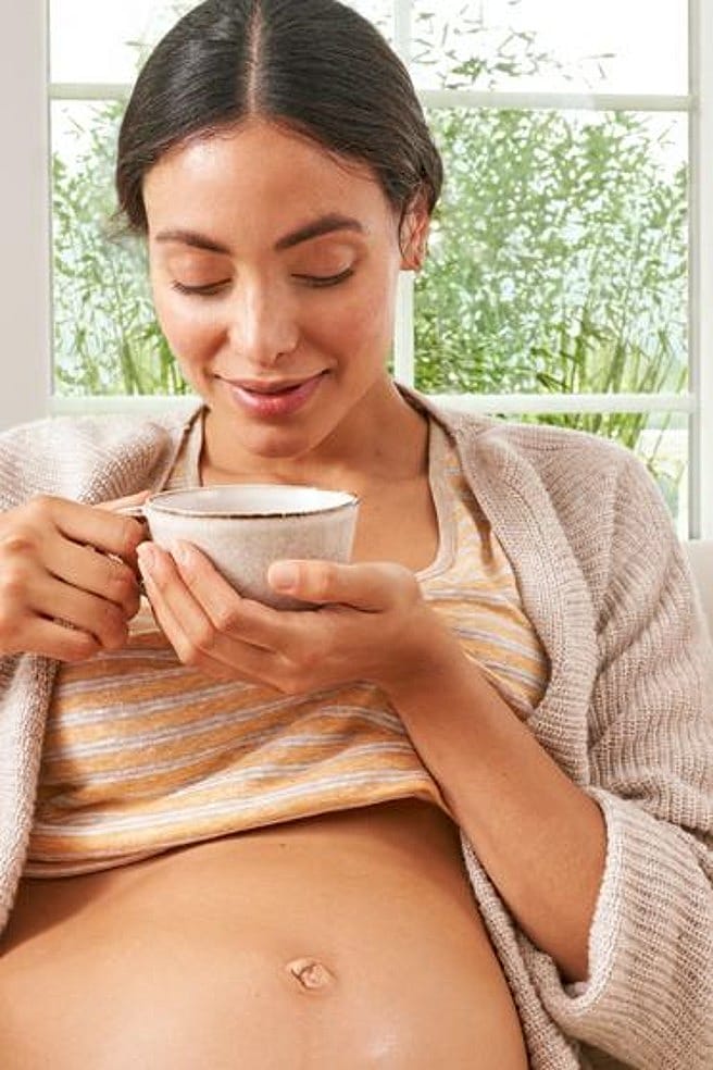 Schwangere Frau am Tee trinken