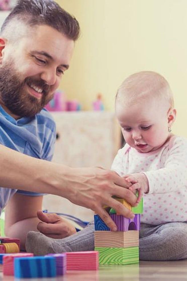 hombre y bebé sentados en el suelo jugando