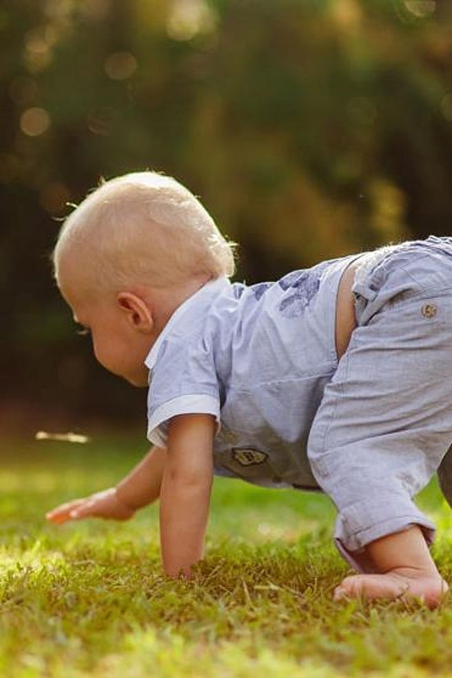 bebe aprendiendo a andar en el cesped