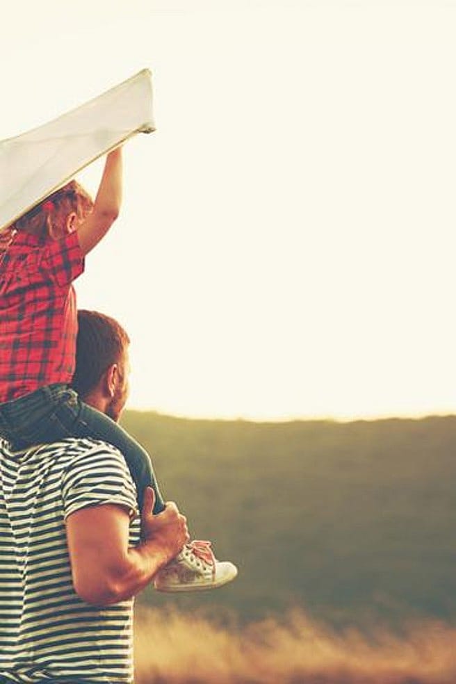 fille sur les épaules du père avec cerf volant