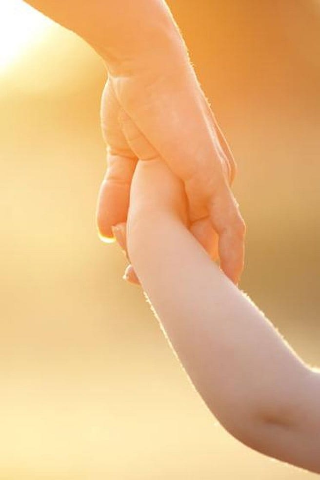 niña de la mano de su padre paseando