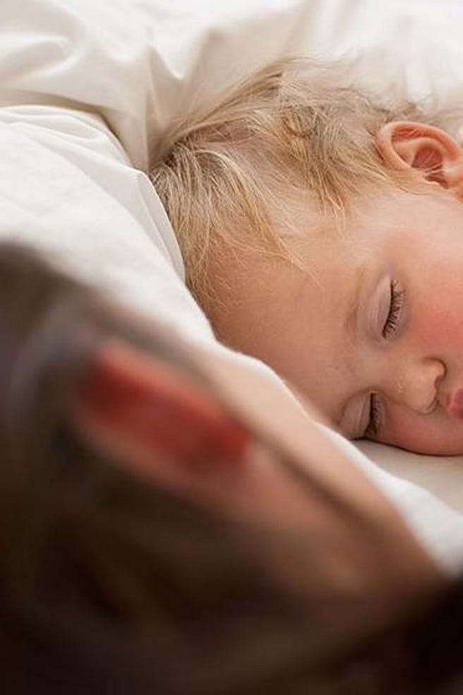 Sovande bebis med mamma