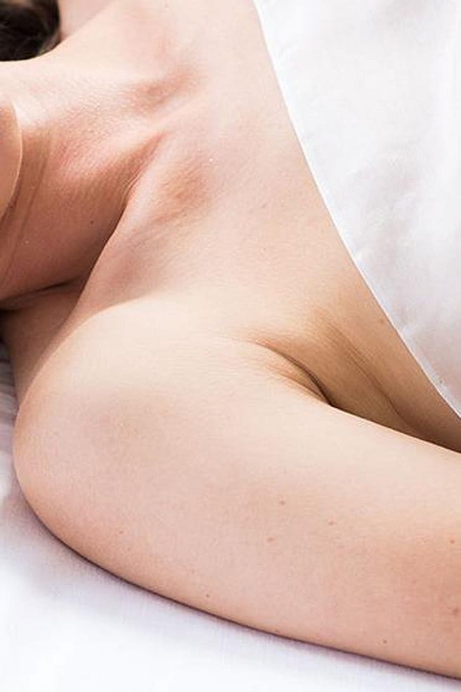 Junge Frau liegt mit geschlossenen Augen im Bett