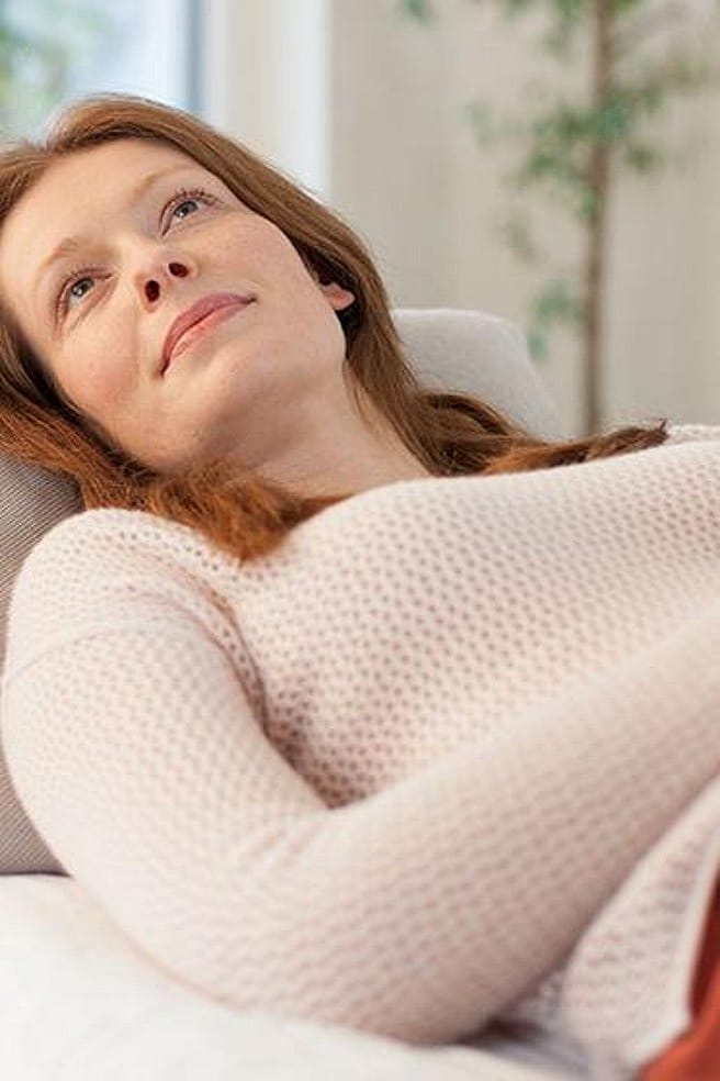 Frau liegt auf Sofa
