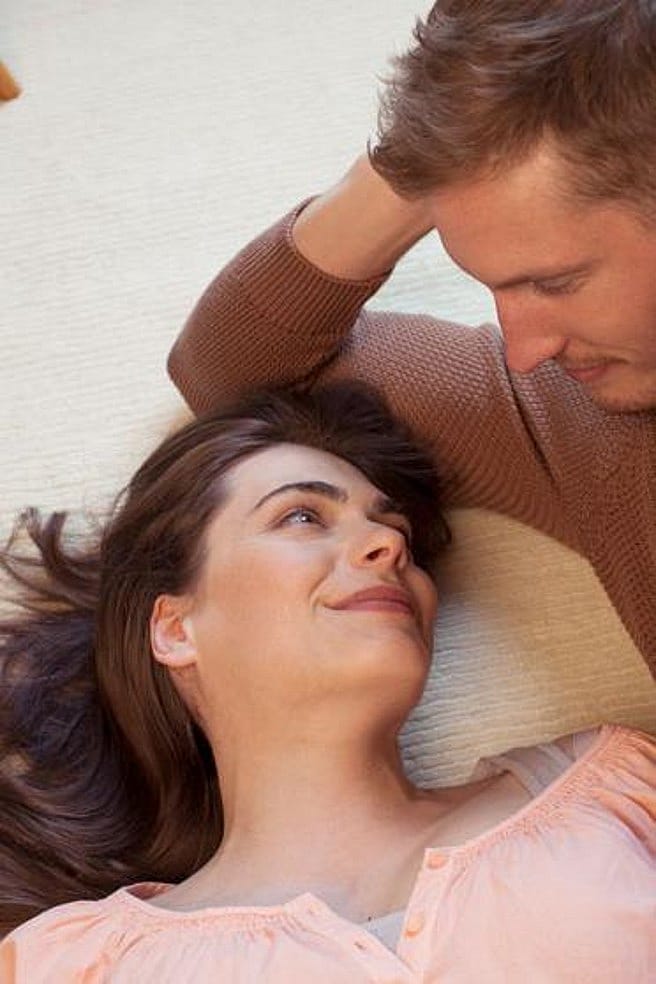 Un couple est couché par terre et se regarde