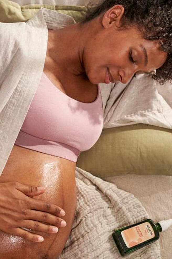 une femme enceinte se masse le ventre