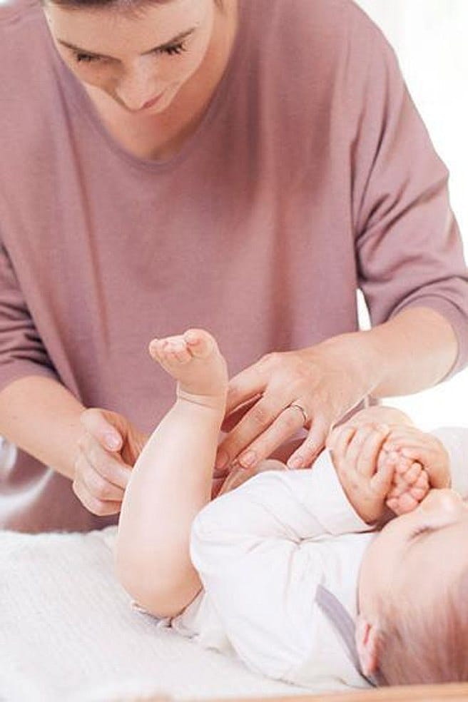 madre cambiando pañal a bebe