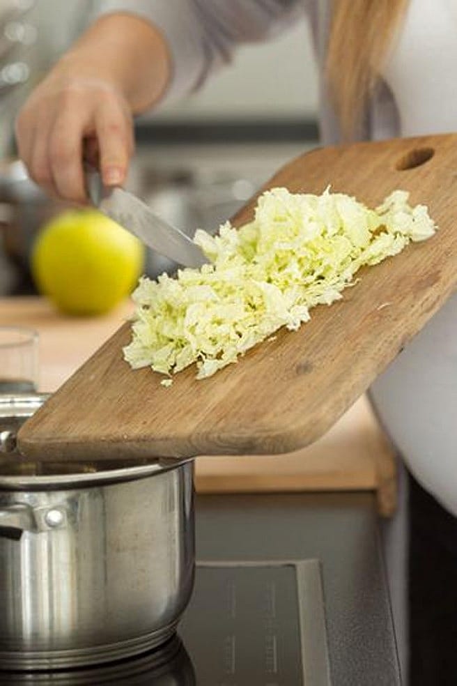 Une femme cuisine des aliments sains