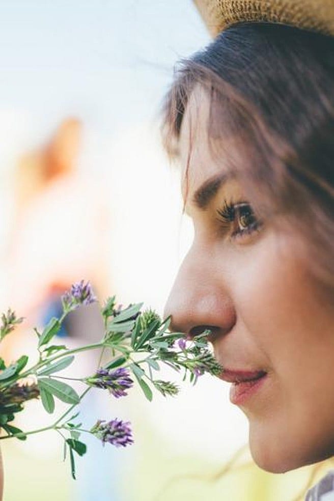 Ragazza annusa fiorellini lilla