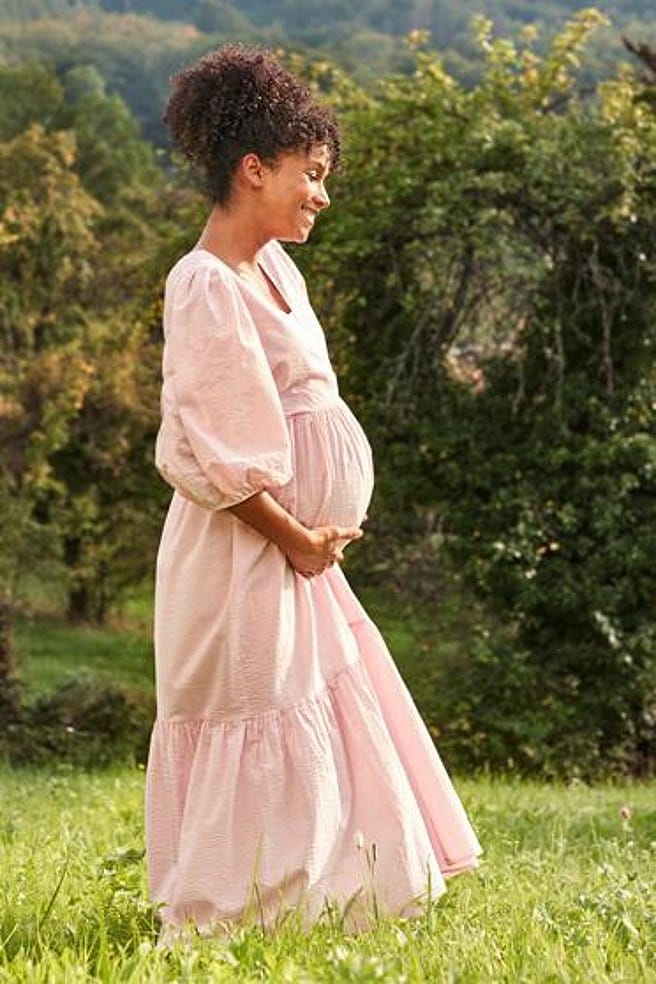 mujer embarazada sando un paseo por el campo